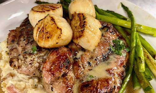 Grilled steak and scallops with mashed potatoes, asparagus—catering from Carriage Towne Bar and Grill.