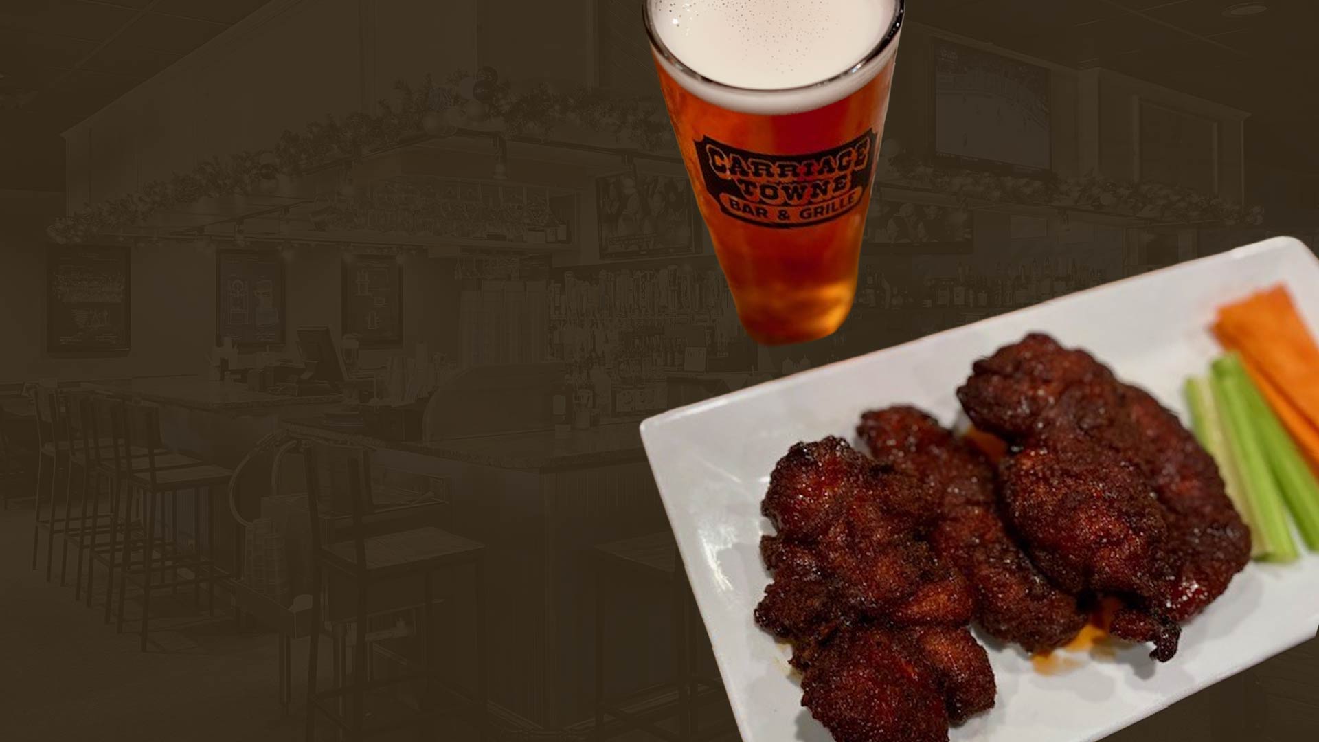 A glass of beer and a plate of chicken wings with celery and carrot sticks on a bar background.